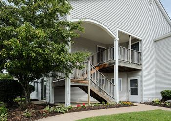 grey siding with mature trees, landscape, and private entrances at regency apartments in Bettendorf Iowa